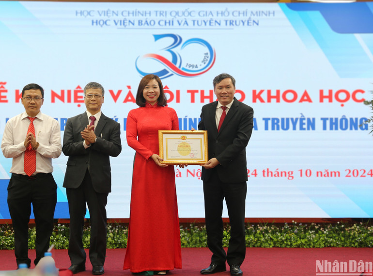 Giáo sư, Tiến sĩ Lê Văn Lợi, Phó Giám đốc Học Viện Chính trị Quốc gia Hồ Chí Minh trao bằng khen của Giám đốc Học viện Chính trị Quốc gia Hồ Chí Minh cho Tạp chí Lý luận chính trị và Truyền thông. (Ảnh: HẢI ĐĂNG)