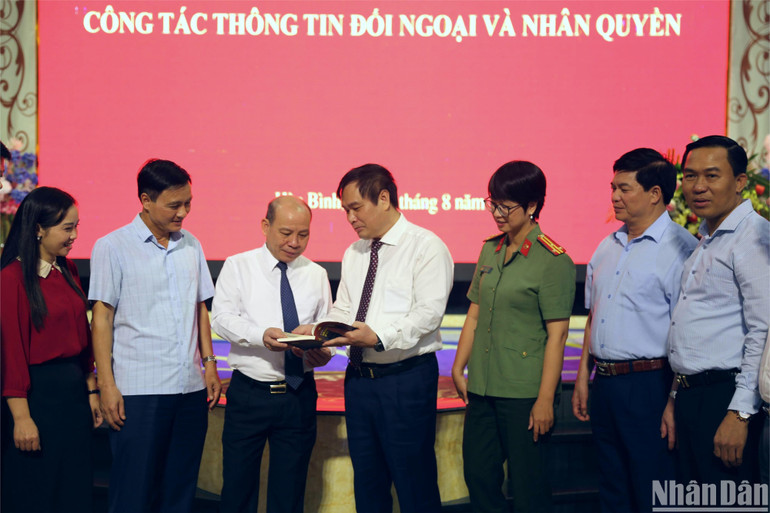 Các đại biểu trao đổi về những ấn phẩm mới được xuất bản tại Việt Nam về công tác thông tin đối ngoại và nhân quyền (Ảnh: HẢI ĐĂNG)