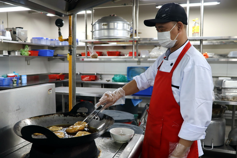Đầu bếp nhà hàng chế biến món chiên.