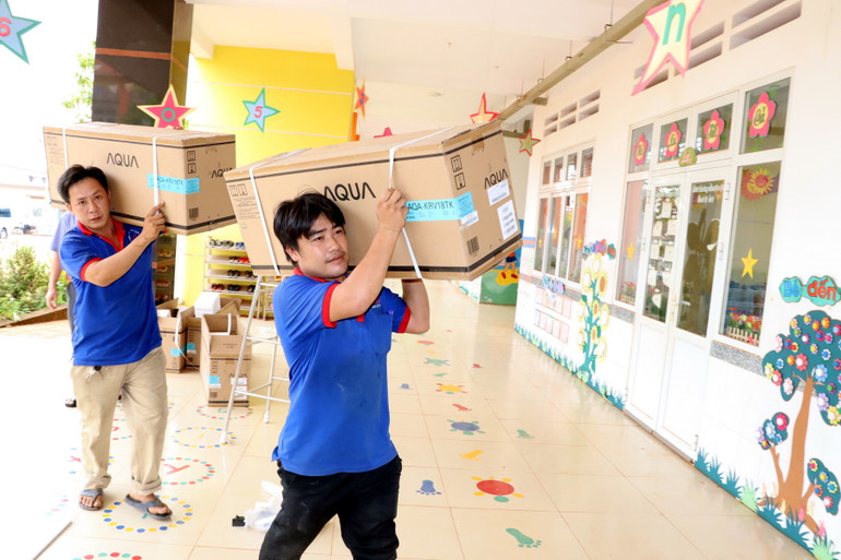 Công nhân vận chuyển máy lạnh đến Trường mầm non Bình Sơn để lắp đặt chiều 11/4.