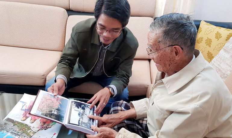 Nghệ sĩ nhiếp ảnh Đặng Văn Thông giới thiệu những tác phẩm của mình với tác giả bài viết (ảnh chụp năm 2019).