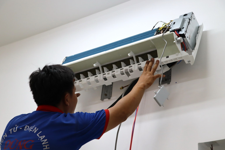 Công nhân bắt máy lạnh bên trong phòng học.