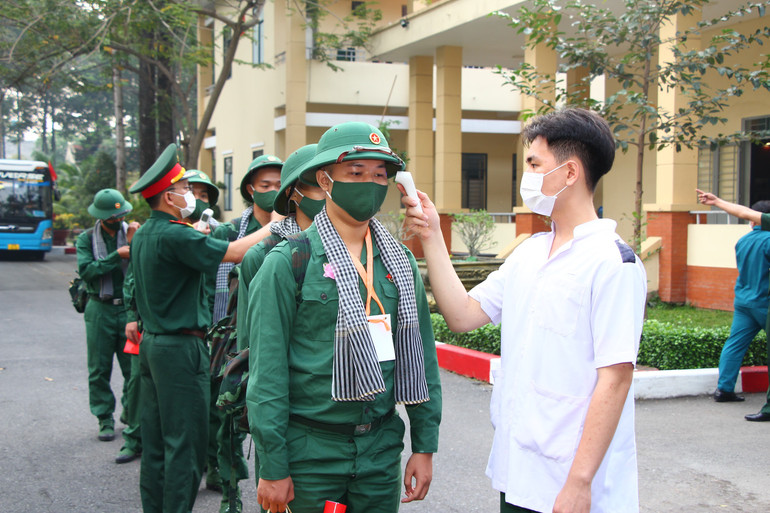 Kiểm tra thân nhiệt thanh niên nhập ngũ.