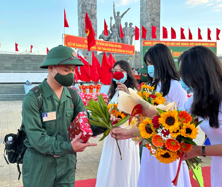 Các em học sinh các trường học tặng hoa chúc mừng các thanh niên trúng tuyển lên đường nhập ngũ.