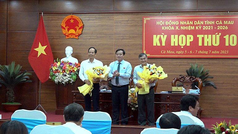 Chủ tịch Ủy ban nhân dân tỉnh Cà Mau (giữa) tặng hoa chúc mừng các đồng chí miễn nhiệm và được bầu bổ sung chức vụ Ủy viên Ủy ban nhân dân tỉnh.