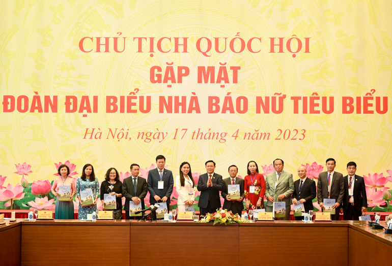 Chủ tịch Quốc hội Vương Đình Huệ trao quà lưu niệm cho các nhà báo nữ tại cuộc gặp mặt.