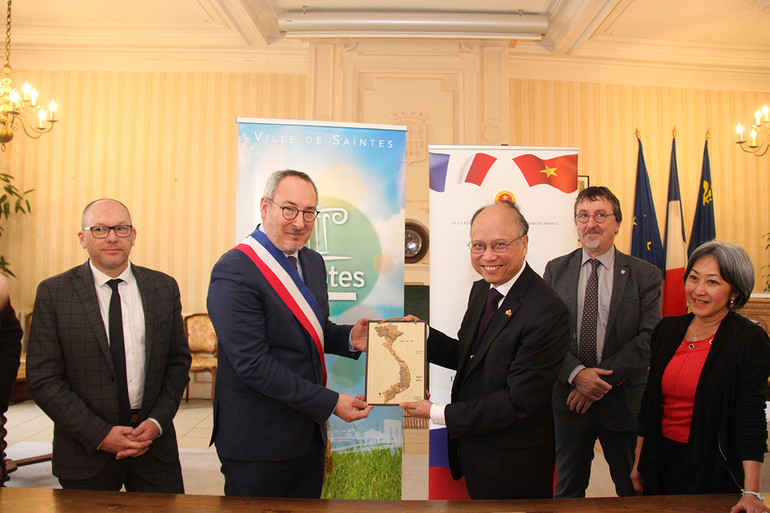 Trao tặng quà lưu niệm cho Thị trưởng Bruno Drapron, Đại sứ Đinh Toàn Thắng mong rằng sẽ có thêm nhiều dự án hợp tác với thành phố Saintes tại Việt Nam. Trao tặng quà lưu niệm cho Thị trưởng Bruno Drapron, Đại sứ Đinh Toàn Thắng mong rằng sẽ có thêm nhiều dự án hợp tác với thành phố Saintes tại Việt Nam.