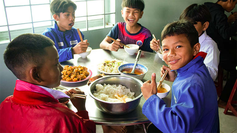 Các em nhỏ bên bữa cơm có thịt.