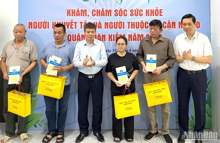 Quận Hoàn Kiếm trao quà và tặng sổ Bảo hiểm xã hội cho người dân thuộc hộ cận nghèo.