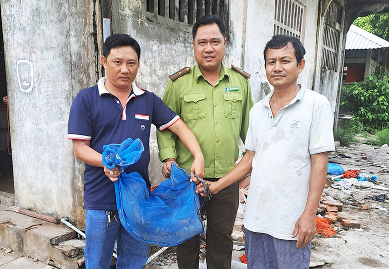 Ông Đào Viên (áo trắng) giao nộp trăn đất cho đơn vị chức năng để thả về môi trường tự nhiên.