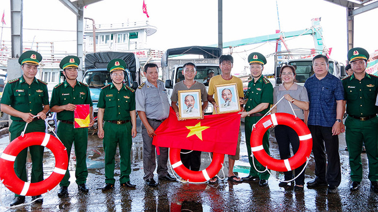 Trao tặng ảnh Bác Hồ, cờ Tổ quốc và phao cứu sinh cho các ngư dân tại cảng cá Trần Đề.
