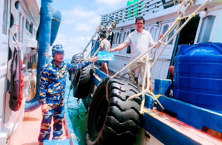 Bộ đội Biên phòng cấp phát tờ rơi tuyên truyền cho ngư dân.