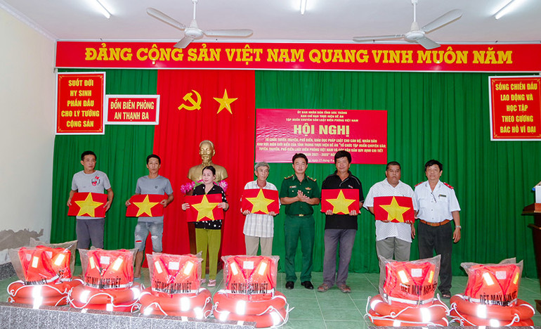 Tặng cờ Tổ quốc và phao cứu sinh cho ngư dân.