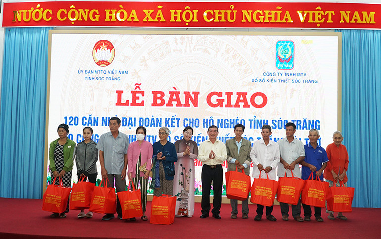 Lãnh đạo tỉnh và Công ty Xổ số Kiến thiết Sóc Trăng tặng quà cho các hộ nghèo được nhận nhà.