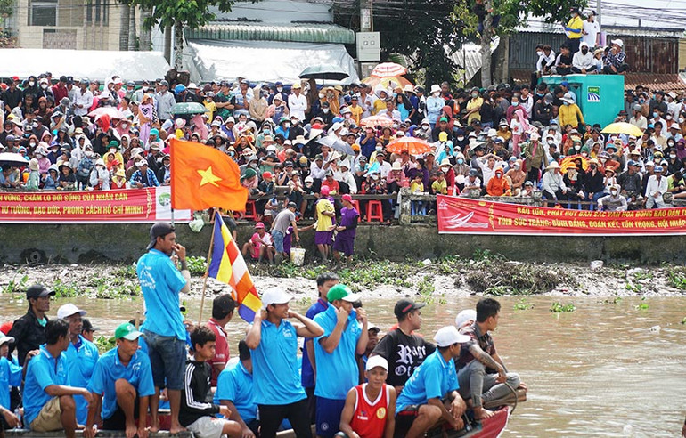 Hàng ngàn người hâm mộ đứng kín hai bờ sông cổ vũ cho các đội ghe