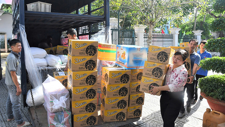 Các tình nguyện viên vận chuyển hàng hóa lên xe.