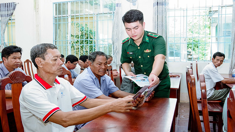 Bộ đội Biên phòng cấp phát tờ rơi tuyên truyền cho ngư dân thị xã Vĩnh Châu.
