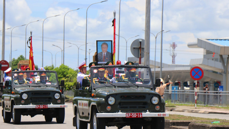 Sau khi thực hiện các nghi thức, 11 giờ 30 phút, linh xa bắt đầu rời sân bay Chu Lai ra Quốc lộ 1A thuộc xã Tam Nghĩa, huyện Núi Thành, đưa linh cữu nguyên Chủ tịch nước Trần Đức Lương di chuyển về nghĩa trang quê nhà ở xã Phổ Khánh, thị xã Đức Phổ. (Ảnh: TTXVN)