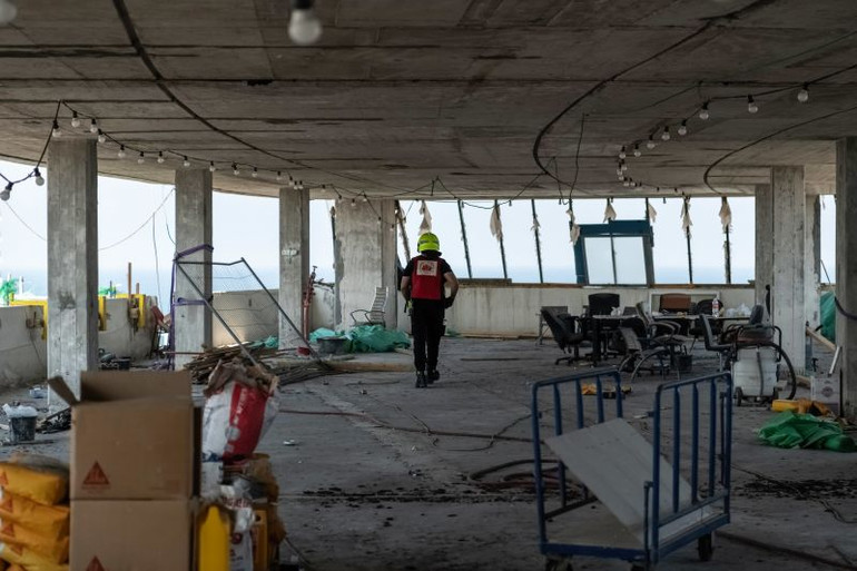 Lính cứu hỏa Israel bên trong một trong những tòa nhà bị hư hại do cuộc tấn công bằng máy bay không người lái của Houthi vào Tel Aviv. (Ảnh: SOPA Images/LightRocket/Getty Images)