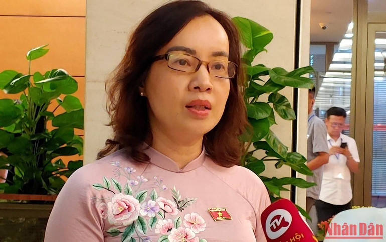 Đại biểu Nguyễn Thị Kim Anh (Bắc Ninh) trao đổi với các phóng viên bên hành lang Quốc hội. (Ảnh: TRUNG HƯNG)