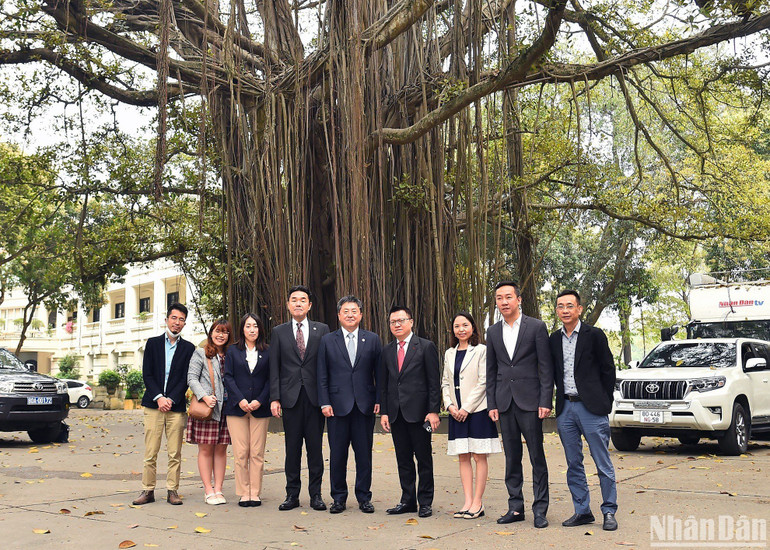 Tổng Biên tập Lê Quốc Minh, Trưởng Đại diện JICA tại Việt Nam Shimizu Akira cùng đại diện Báo Nhân Dân và JICA chụp ảnh lưu niệm bên gốc đa Hàng Trống. (Ảnh: THỦY NGUYÊN)