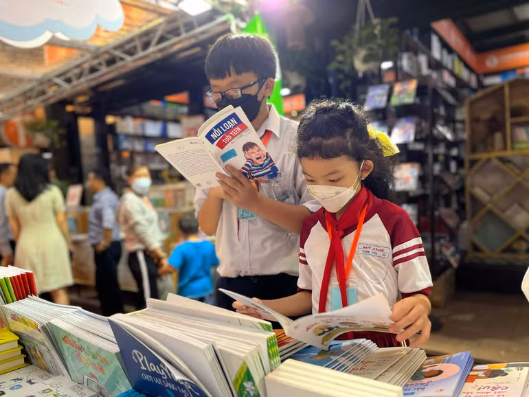 Độc giả nhí đọc sách tại Hội sách thiếu nhi.