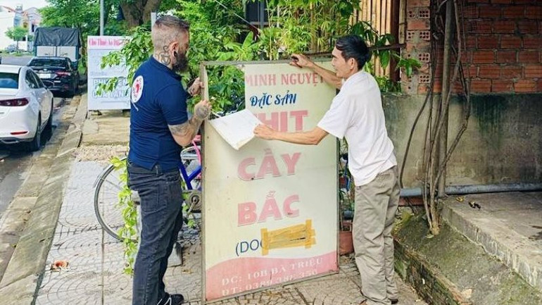 Người dân Hội An tháo dỡ biển hiệu sau khi thực hiện cam kết chấm dứt việc buôn bán thịt chó, mèo. (Ảnh: FOUR PAWS)
