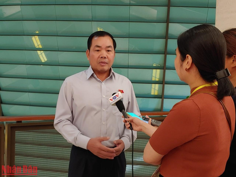 Đại biểu Nguyễn Quang Huân - Đoàn đại biểu Quốc hội tỉnh Bình Dương chia sẻ với phóng viên bên hành lang Quốc hội. (Ảnh: TRUNG HƯNG)