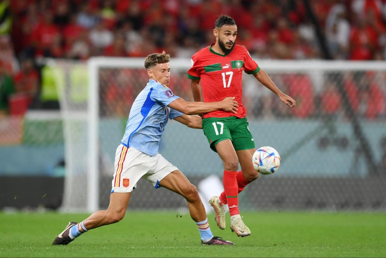 Tây Ban Nha (áo xanh) kiểm soát thế trận nhưng bế tắc trước hệ thống phòng ngự đa tầng của Maroc. (Ảnh: FIFA)