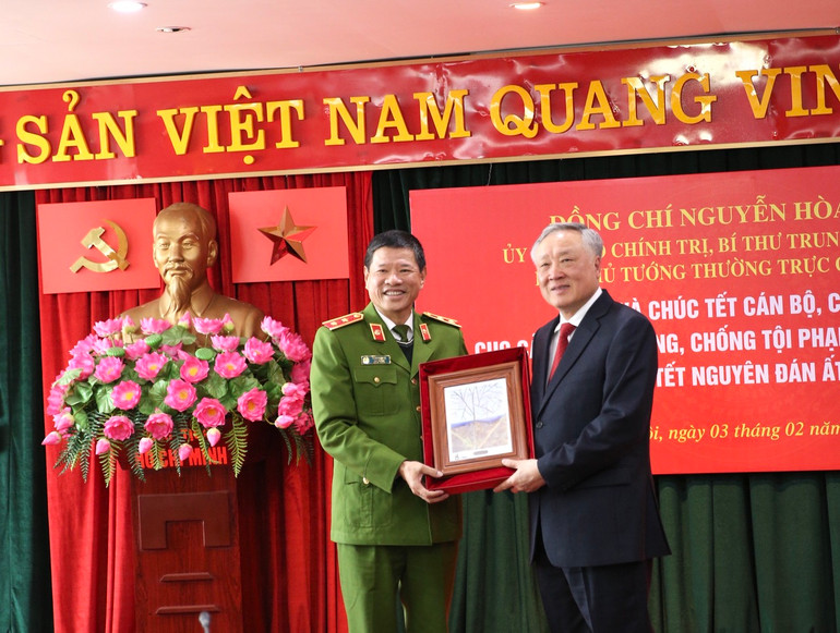 Trung tướng Trần Minh Lệ, Cục trưởng Cục Cảnh sát phòng, chống tội phạm về môi trường trao tặng Phó Thủ tướng Thường trực Chính phủ Nguyễn Hòa Bình bức tranh lưu niệm về bảo vệ môi trường. (Ảnh: TÂM PHẠM)