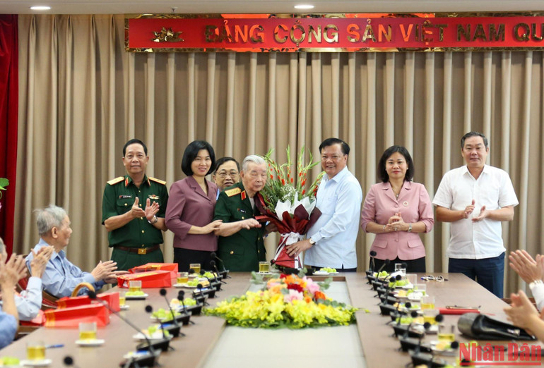 Bí thư Thành ủy Đinh Tiến Dũng cùng các đồng chí lãnh đạo thành phố tặng hoa Đại tướng Nguyễn Quyết. (Ảnh: DUY LINH)