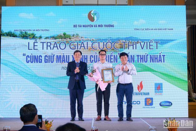 Phó Tổng Biên tập Báo Nhân Dân Quế Đình Nguyên (ngoài cùng bên phải) và Phó Chủ nhiệm Ủy ban Khoa học, Công nghệ và Môi trường của Quốc hội Tạ Đình Thi trao giải và tặng hoa cho tác giả đoạt giải Nhì.