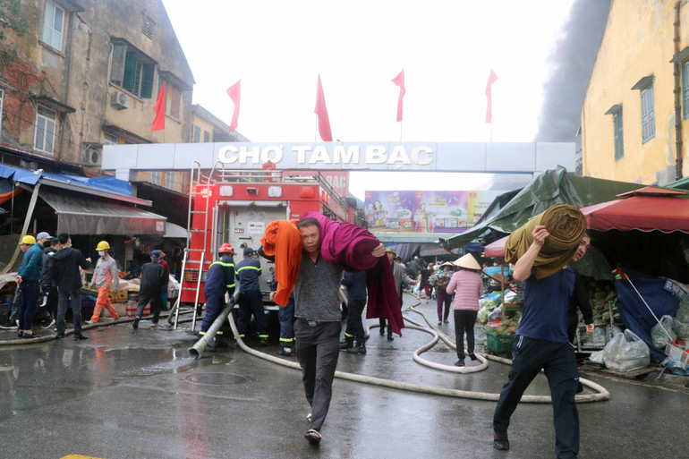 Người dân sơ tán tài sản khỏi chợ. (Ảnh: Hoàng Ngọc/TTXVN)