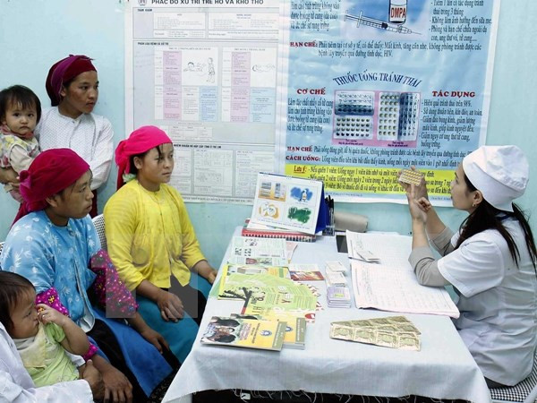 Cán bộ y tế tư vấn chăm sóc sức khỏe sinh sản cho chị em phụ nữ vùng cao. (Ảnh: TTXVN)
