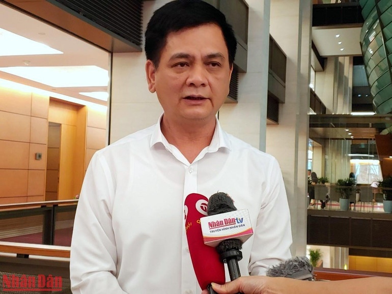 Đại biểu Nguyễn Lâm Thành (Thái Nguyên) trao đổi bên hành lang Quốc hội. (Ảnh: TRUNG HƯNG)