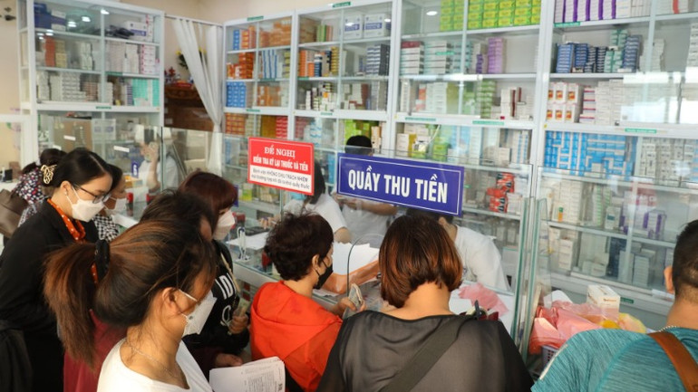 Bệnh nhân xếp hàng chờ mua thuốc tại bệnh viện. (Ảnh: TTXVN)