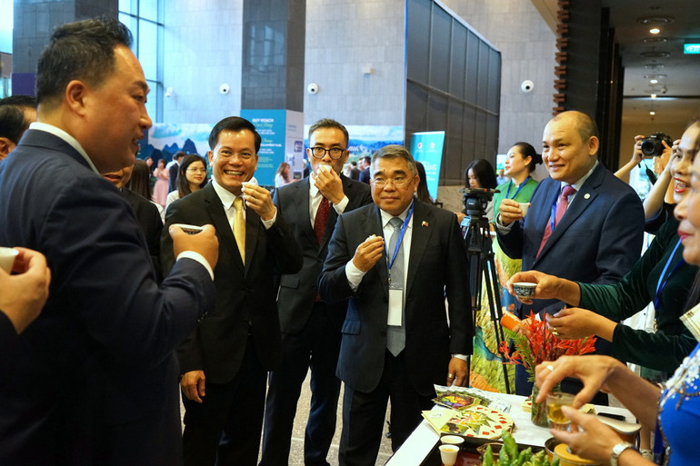 Các đại biểu thưởng thức trà Cao Bằng và tham quan gian trưng bày một số đặc sản, các sản phẩm OCOP của tỉnh bên lề hội nghị. (Ảnh: TRUNG HƯNG)