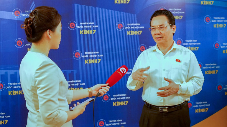 Đại biểu Hoàng Văn Cường (Hà Nội) trao đổi với báo chí bên hành lang Quốc hội. (Ảnh: TRUNG HƯNG)