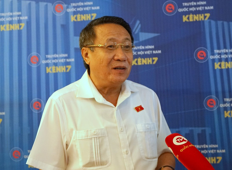 Đại biểu Hà Sỹ Đồng (Quảng Trị) trao đổi với báo giới bên hành lang Quốc hội sáng 23/6. (Ảnh: TRUNG HƯNG)