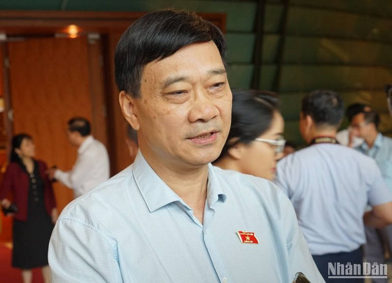 Ủy viên Ủy ban Thường vụ Quốc hội, Chủ nhiệm Ủy ban Kinh tế của Quốc hội Vũ Hồng Thanh chia sẻ với phóng viên bên hành lang Quốc hội sáng 24/6. (Ảnh: TRUNG HƯNG)