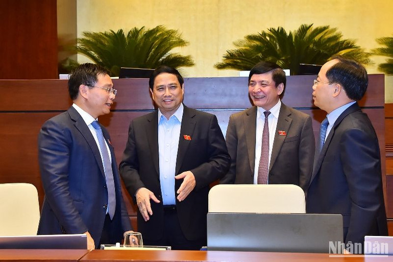 Bộ trưởng Nguyễn Văn Thắng trao đổi với các đại biểu bên lề phiên chất vấn. (Ảnh: THỦY NGUYÊN)