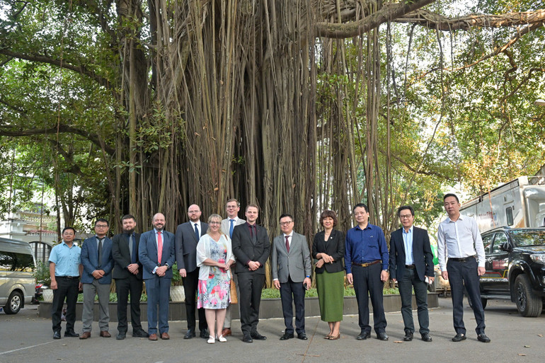Các đại biểu chụp ảnh lưu niệm bên gốc đa tại trụ sở Báo Nhân Dân, số 71 Hàng Trống, Hoàn Kiếm, Hà Nội. (Ảnh: THẾ ĐẠI)