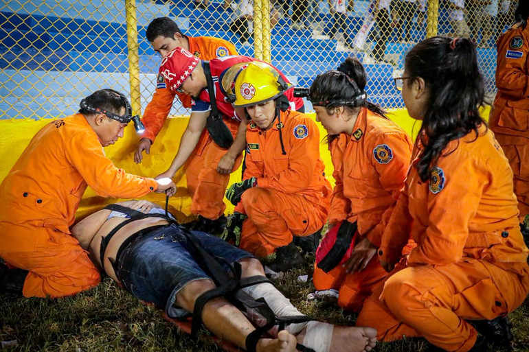 Những người bị thương có dấu hiệu ngạt thở được các nhân viên cứu trợ đưa xuống khu vực đường biên và sân cỏ. (Ảnh: Cơ quan Bảo vệ dân sự El Salvador)