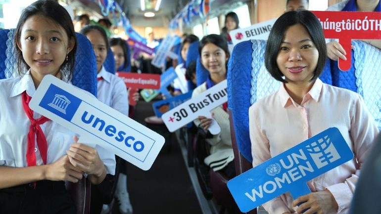 Các em học sinh tham gia chuyến xe bus “Beijing+30 Bus Tour”, ghi nhận những thành tựu về bình đẳng giới của Việt Nam trong 30 năm thực hiện Tuyên bố và Cương lĩnh hành động Bắc Kinh.