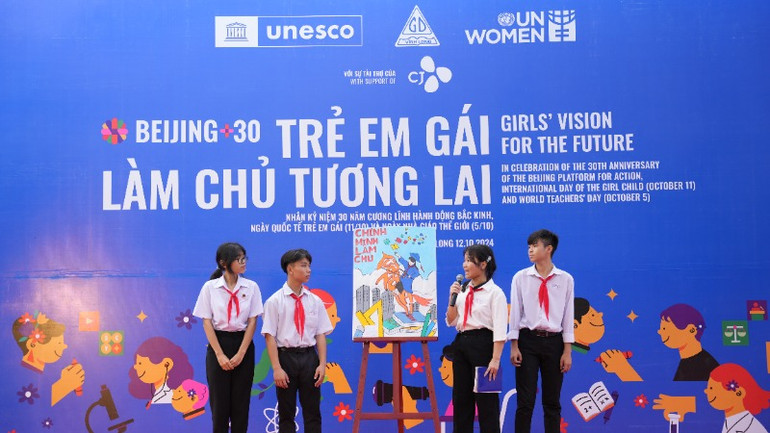 Các em học sinh thuyết minh về sản phẩm tranh cổ động trong khuôn khổ cuộc thi sáng tác tranh cổ động với chủ đề “Trẻ em gái làm chủ tương lai”.