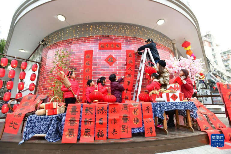 Người dân thành phố Kiến Đức, tỉnh Chiết Giang, Trung Quốc treo câu đối Tết Nguyên Đán và đèn lồng mừng năm mới 2023. (Ảnh: Tân Hoa Xã)