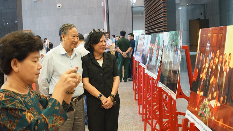 Các đại biểu tham quan triển lãm ảnh về công tác phân giới, cắm mốc biên giới trên đất liền Việt Nam-Trung Quốc bên lề hội nghị. (Ảnh: TRUNG HƯNG)