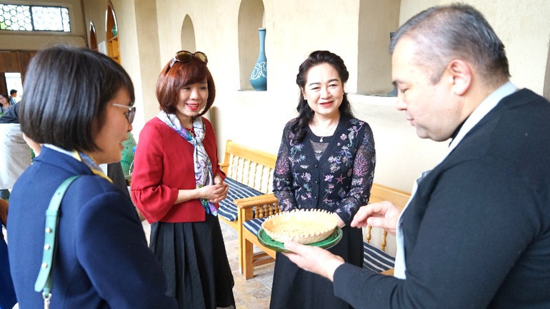 Nghệ nhân chủ cơ sở trưng bày gốm truyền thống ở Thủ đô Tashkent trân trọng mời Phu nhân Nguyễn Thị Thanh Nga món bánh do gia đình tự làm. Nghệ nhân chủ cơ sở trưng bày gốm truyền thống ở Thủ đô Tashkent trân trọng mời Phu nhân Nguyễn Thị Thanh Nga món bánh do gia đình tự làm.