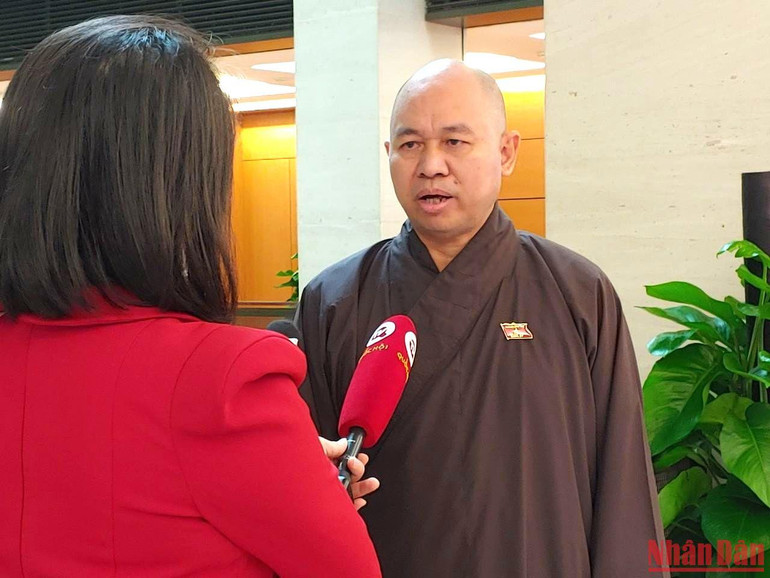 Thượng tọa Thích Đức Thiện - Đại biểu Quốc hội tỉnh Điện Biên trao đổi bên hành lang Quốc hội. (Ảnh: TRUNG HƯNG)