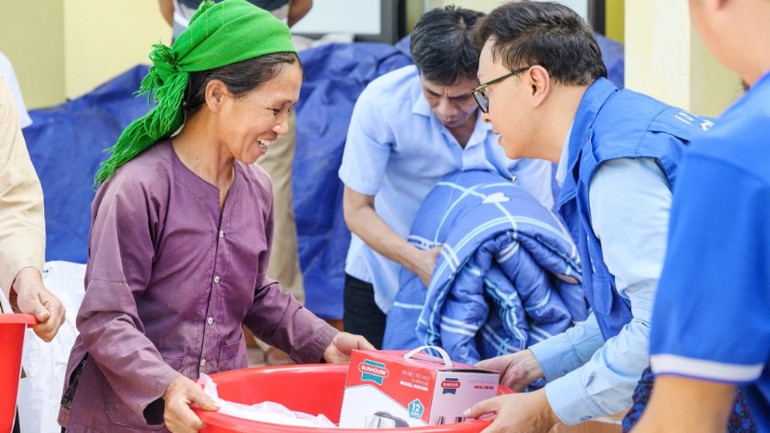 Cán bộ IOM trao hỗ trợ cho người dân bị ảnh hưởng bởi bão lũ. (Ảnh: IOM Việt Nam)